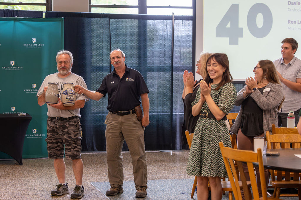 The applause was long and loud for facilities employees David, left, and Ron Lucia. The brothers each recently celebrated their 40th year at the College.